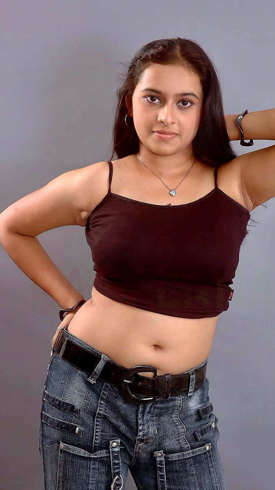 Young Woman in Maroon Crop Top and Blue Jeans Posing Against Grey Background, Srividya, tamil actress, navel HD phone wallpaper
