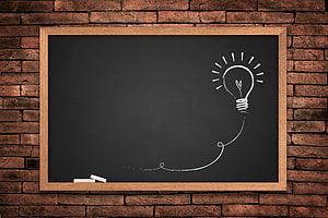 Chalkboard with Lightbulb Sketch on Rustic Brick Wall HD wallpaper