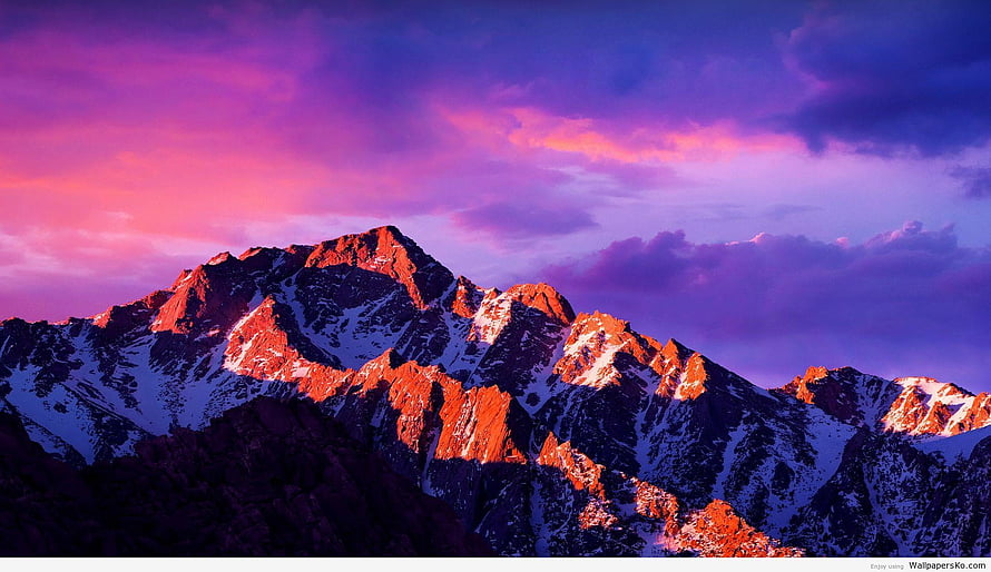 Snowy Mountain Peaks Bathed in Golden Sunset Light Against a Vibrant Purple and Pink Sky HD wallpaper