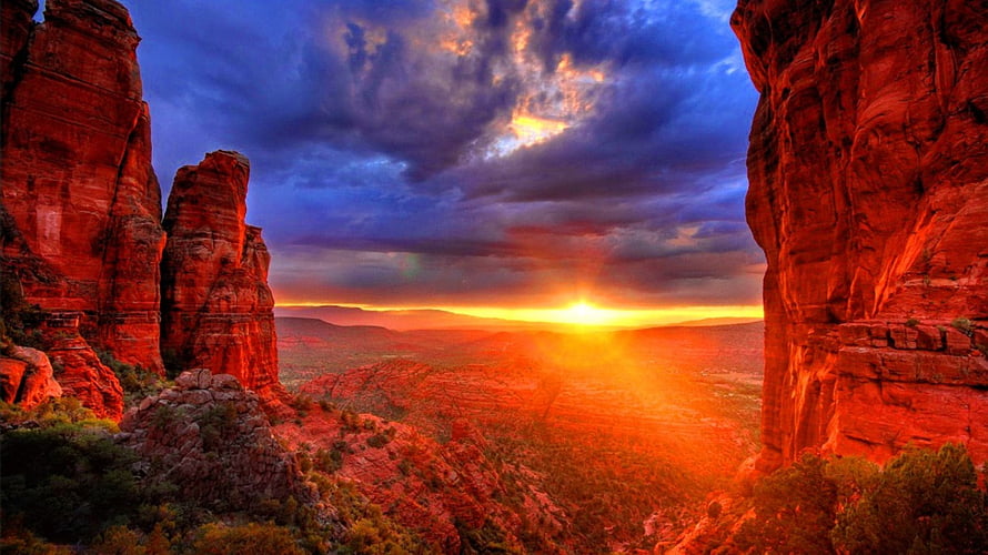 Dramatic Arizona Canyon Sunset with Fiery Red Rock Formations and Stormy Sky HD wallpaper
