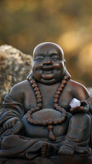 Smiling Laughing Buddha Statue with Prayer Beads and Crystal in Serene Setting HD phone wallpaper