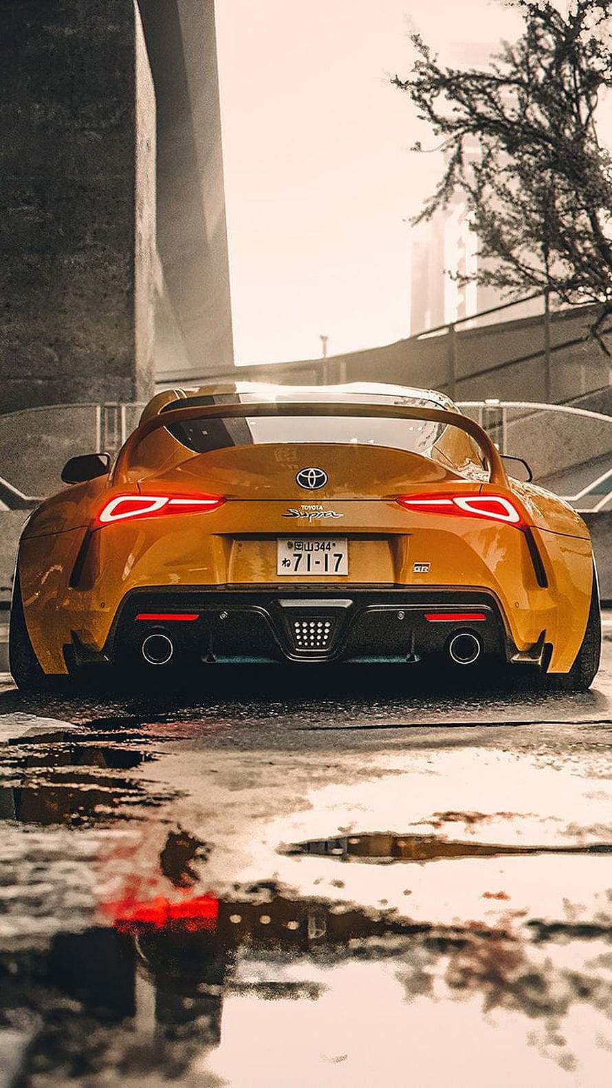 Rear View of Orange Toyota Supra GR on Wet Urban Street HD phone wallpaper