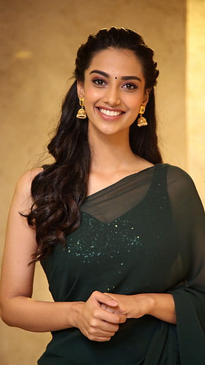 Meenakshi Chaudhary in a dark green sequined saree with gold jhumka earrings HD phone wallpaper