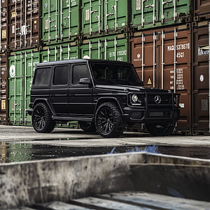 Matte Black Mercedes-Benz G-Class SUV Parked in Front of Stacked Shipping Containers HD phone wallpaper