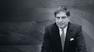 Ratan Tata in a formal suit and patterned tie against a textured studio backdrop HD wallpaper