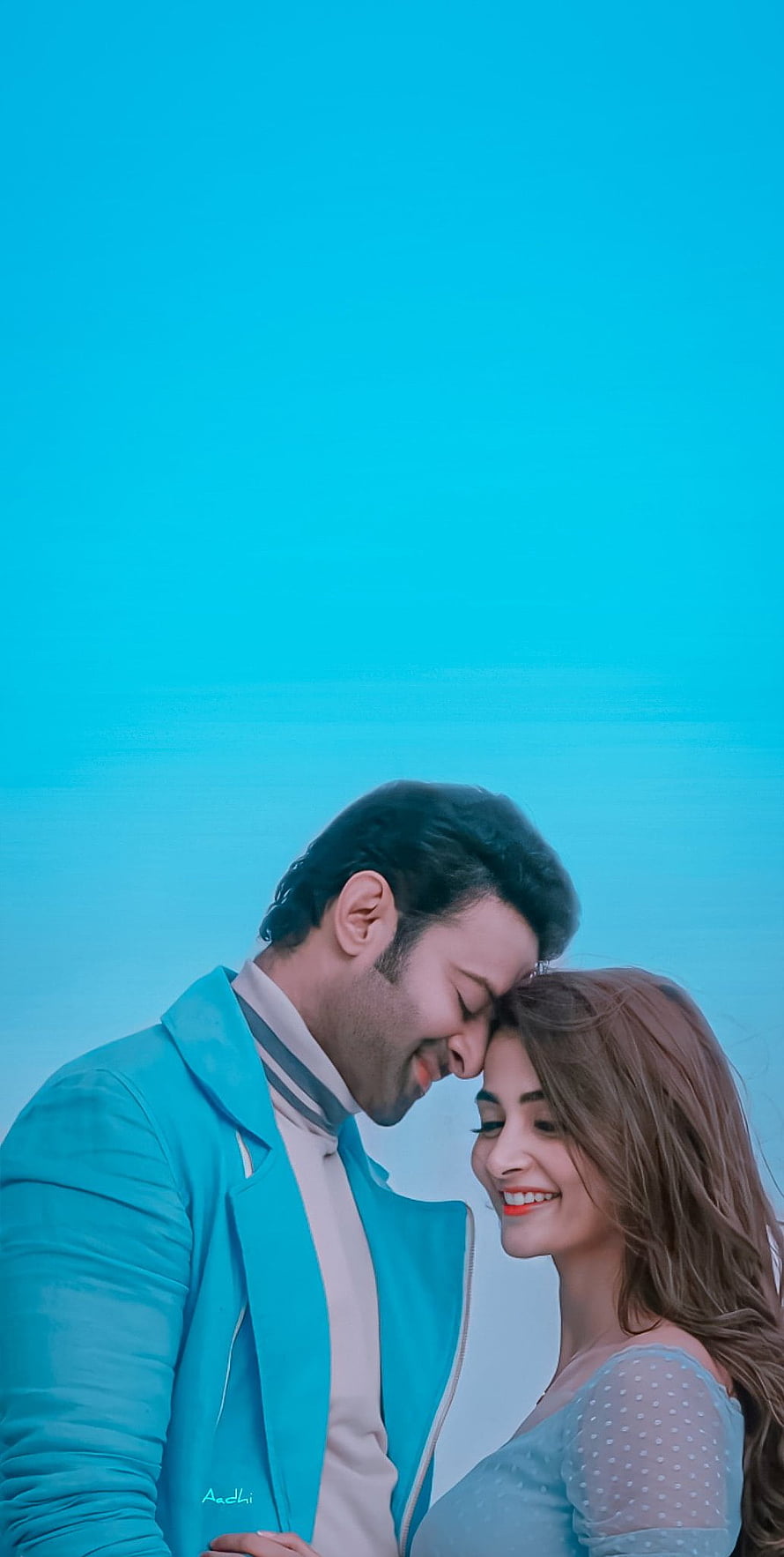 Radhe Shyam and Pooja Hegde in a tender forehead touch against a bright blue sky HD phone wallpaper
