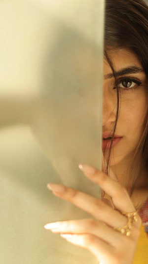Sreeleela Peeking From Behind a Wall in Warm Golden Light HD phone wallpaper