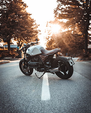 White BMW R100R Cafe Racer Motorcycle Parked on a Tree-Lined Road at Golden Hour HD phone wallpaper