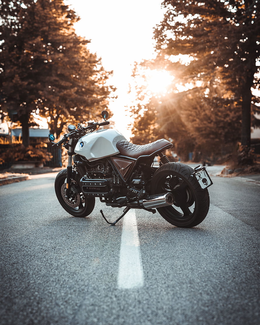 White BMW R100R Cafe Racer Motorcycle Parked on a Tree-Lined Road at Golden Hour HD phone wallpaper