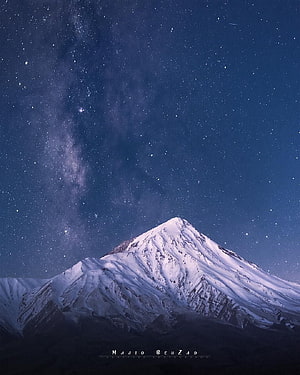 Milky Way Galaxy Arching Over Snow-Capped Mount Damavand in Iran at Night HD phone wallpaper