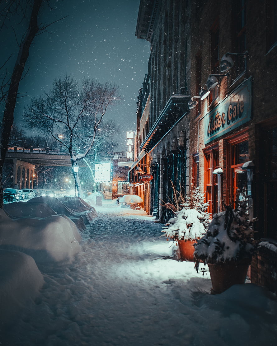 Snowy Night Street Scene With Glowing Cafe And Brick Buildings HD phone wallpaper
