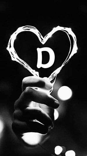 Hand Holding Glowing Heart Shaped Light with Letter D in Black and White HD phone wallpaper
