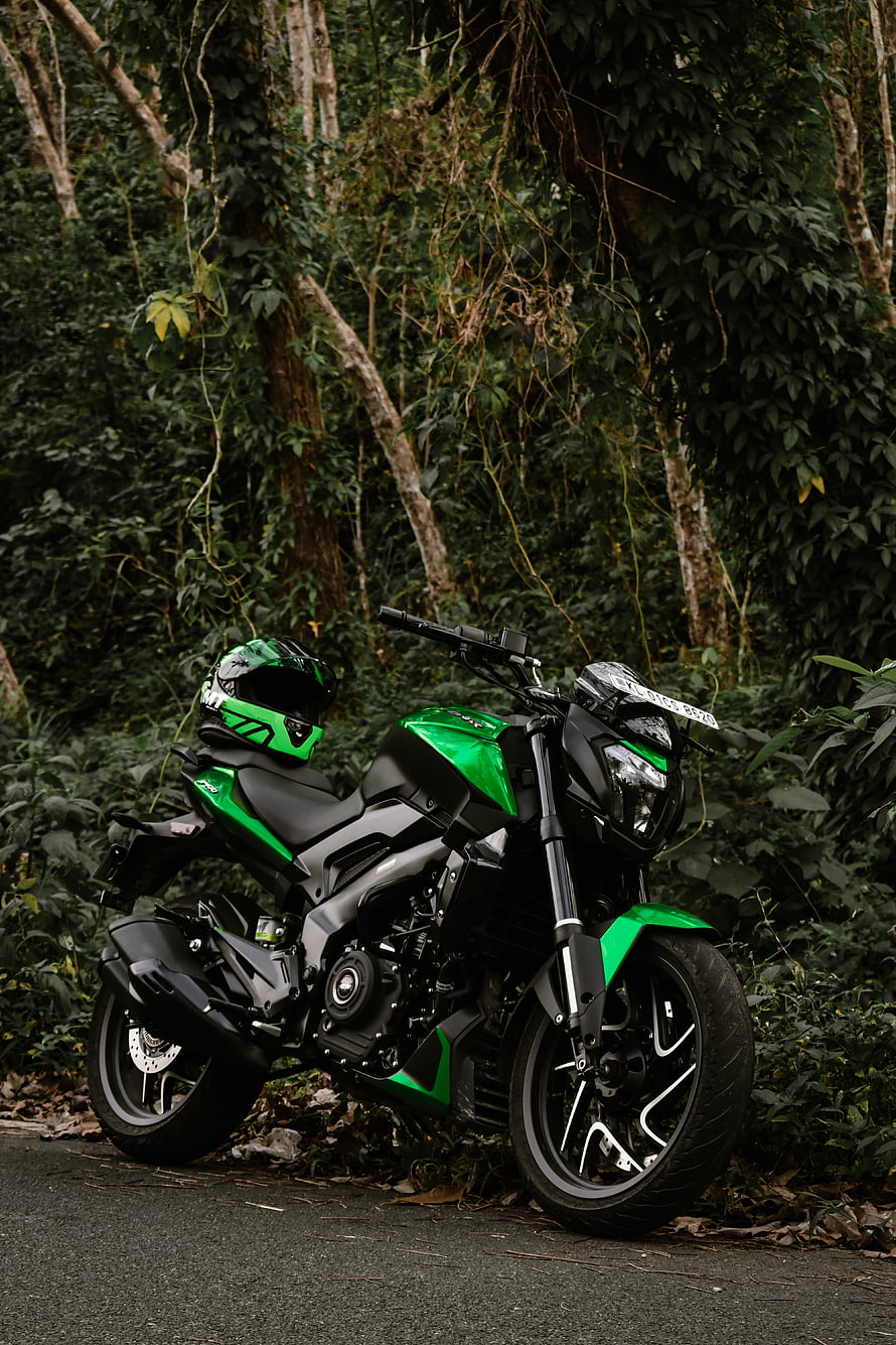 Bajaj Dominar 400 Motorcycle in Green and Black Parked on a Forest Road HD phone wallpaper
