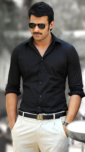 Prabhas in a black shirt and sunglasses posing with hands in pockets HD phone wallpaper