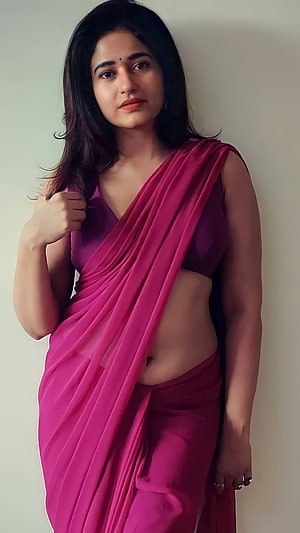 Woman in a vibrant pink saree posing against a plain wall with a confident expression, Poonam Bajwa, tamil actress, saree beauty, navel HD phone wallpaper