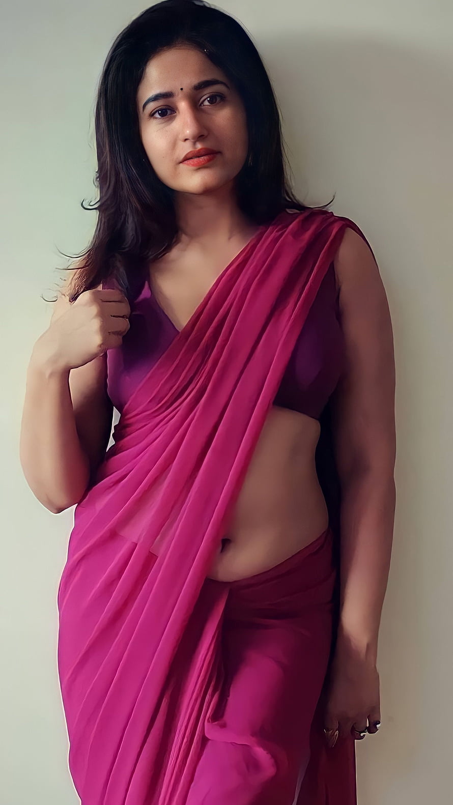 Woman in a vibrant pink saree posing against a plain wall with a confident expression, Poonam Bajwa, tamil actress, saree beauty, navel HD phone wallpaper
