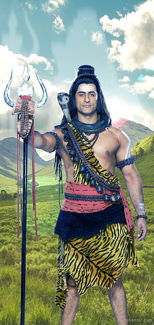 Lord Shiva in tiger skin holding trident and rudraksha beads in a green mountain landscape HD phone wallpaper