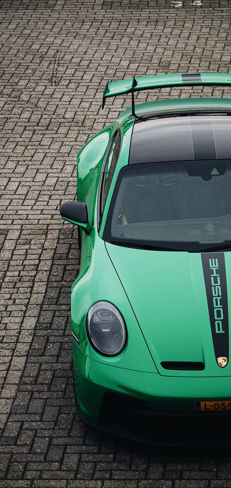 Green Porsche GT3 RS with Carbon Fiber Roof and Rear Wing on Cobblestones HD phone wallpaper