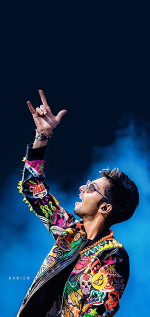 Anirudh Ravichander performing on stage in a colorful graphic jacket HD phone wallpaper