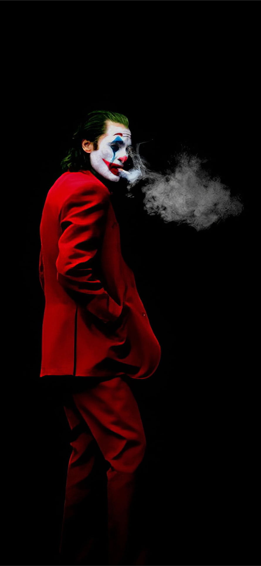 Joker in red suit smoking cigarette against black background HD phone wallpaper