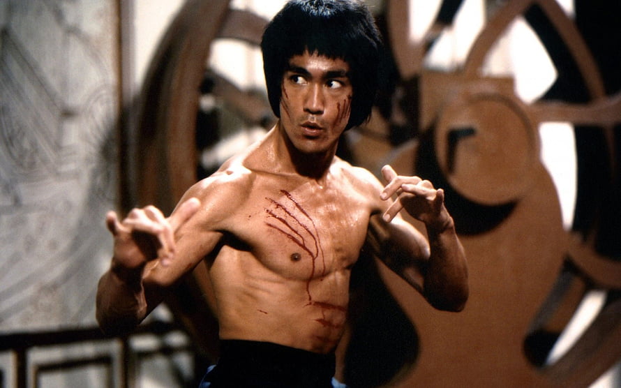 Bruce Lee in a fighting stance with visible battle scars from the film Enter The Dragon HD wallpaper