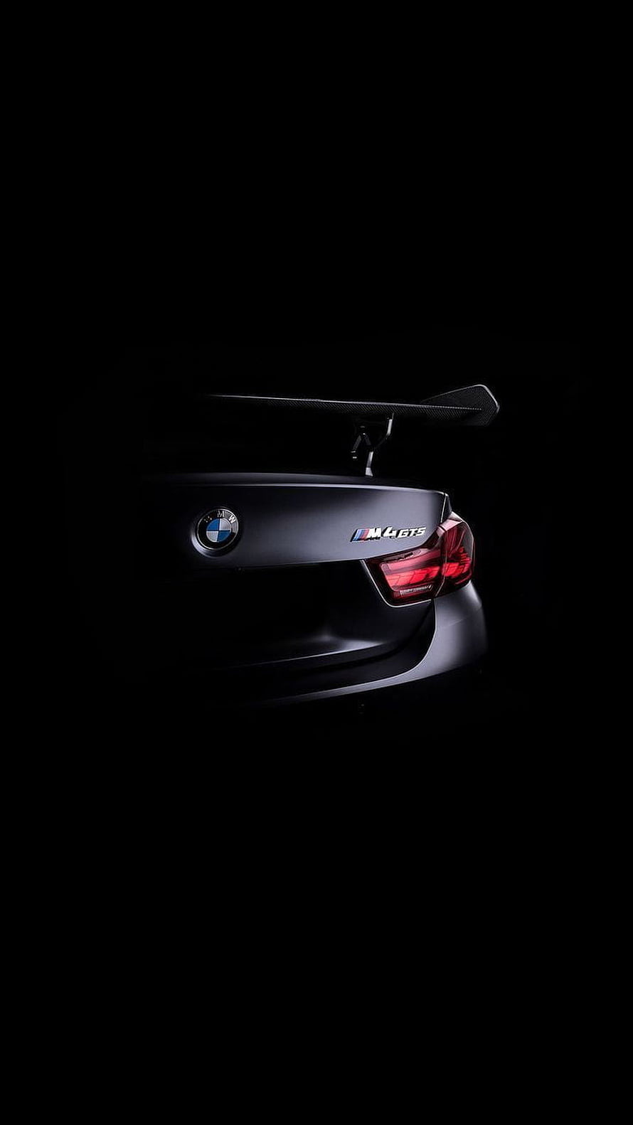 BMW M4 GTS Rear View with Carbon Fiber Spoiler in Dramatic Black Studio Lighting HD phone wallpaper