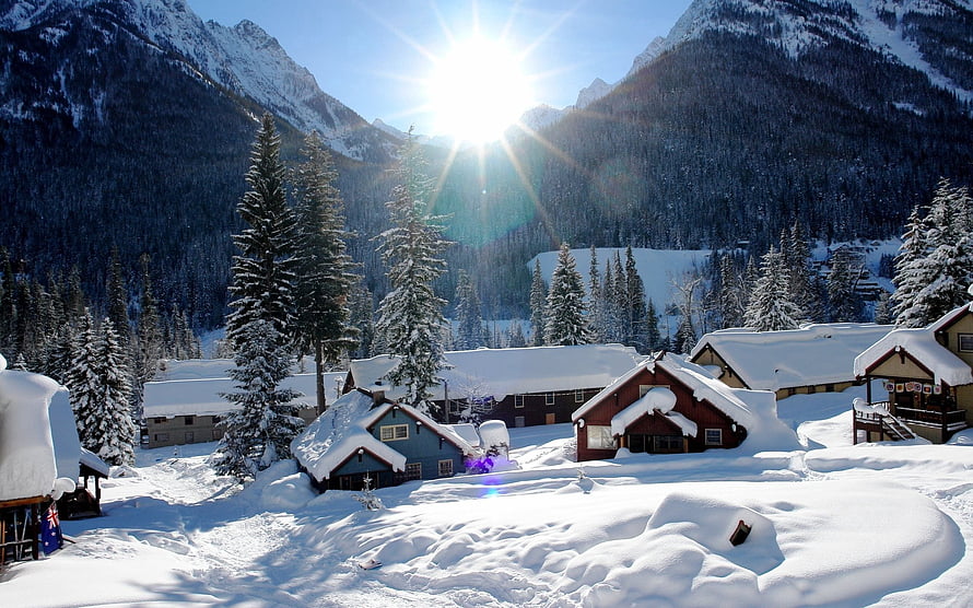 Snow-Covered Alpine Village With Chalets And Evergreen Trees Under Bright Winter Sun HD wallpaper