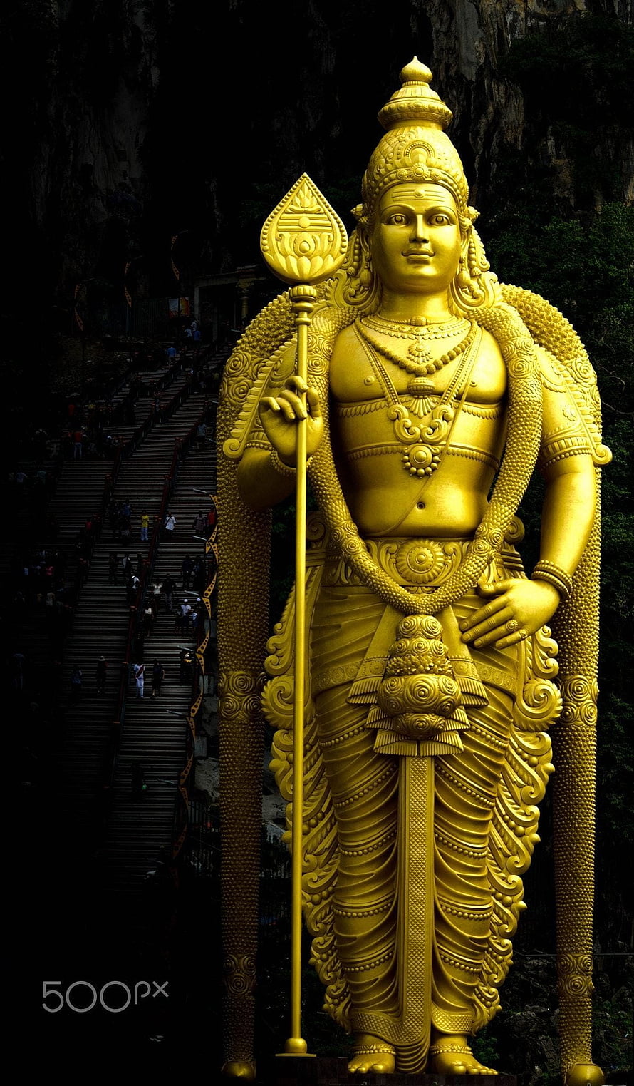 Golden Murugan Statue at Batu Caves with Serpent Hood and Devotees on Stairs HD phone wallpaper