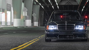 Black Mercedes-Benz W124 Sedan Front View Under Urban Bridge at Night HD wallpaper
