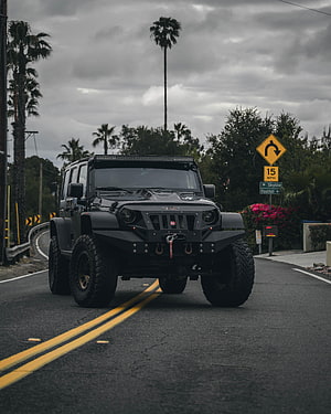 Black Modified Jeep Wrangler with Off-Road Bumper and LED Light Bar on Coastal Road HD phone wallpaper