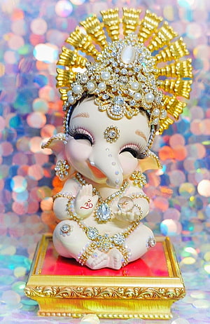 Adorned Baby Ganesha Idol with Golden Crown and Jewels on Ornate Pedestal HD phone wallpaper