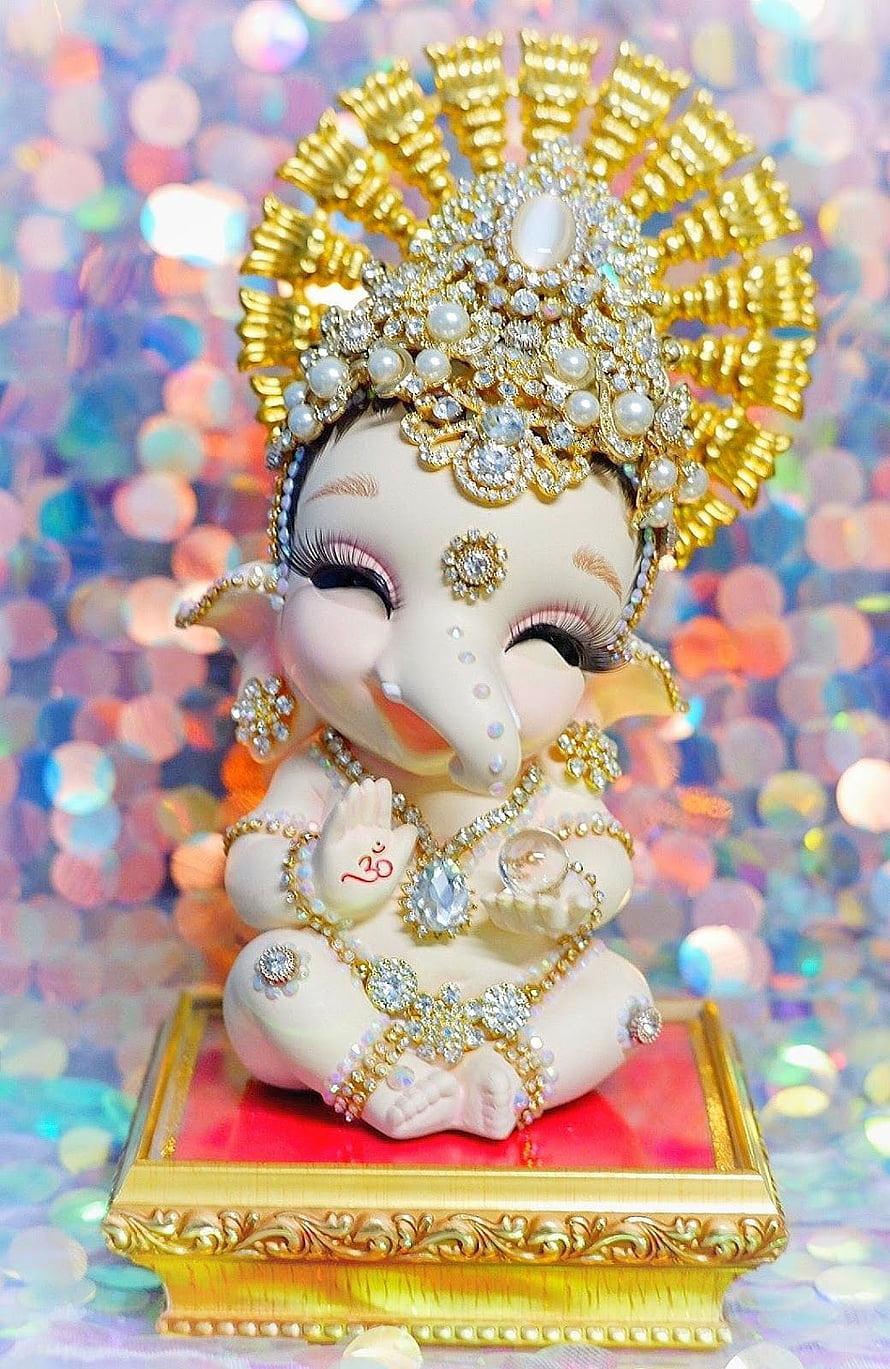 Adorned Baby Ganesha Idol with Golden Crown and Jewels on Ornate Pedestal HD phone wallpaper