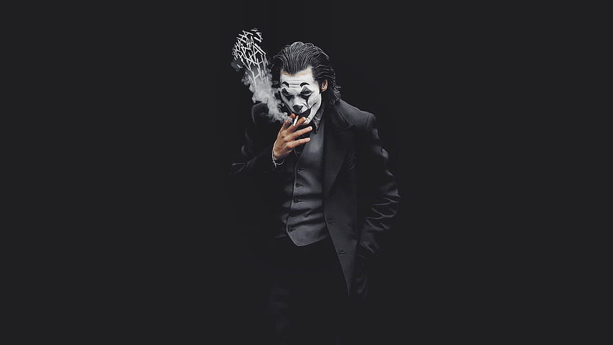 Joaquin Phoenix as the Joker smoking a cigarette in a dark suit against a black background HD wallpaper