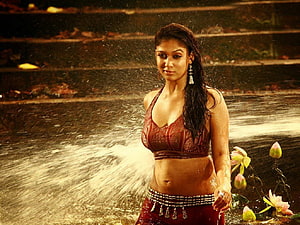 Nayanthara in Traditional Red Attire Standing in Water with Lotus Flowers HD wallpaper