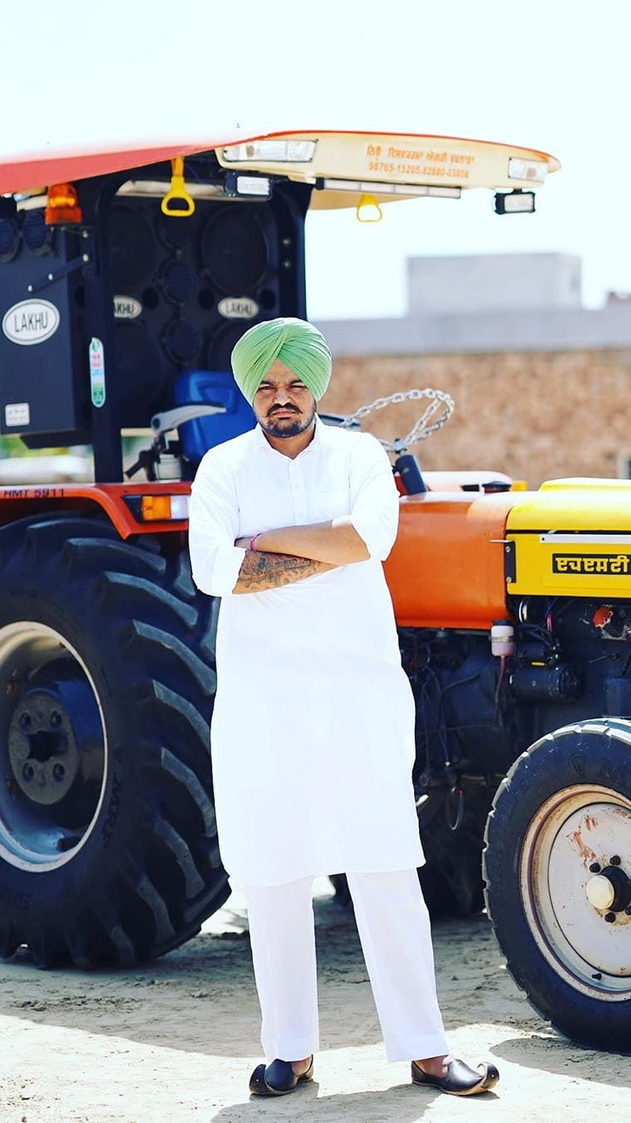 Man in white kurta and green turban standing confidently in front of a customized orange tractor with large speakers, Sidhu Moose Wala, Tractor Background HD phone wallpaper