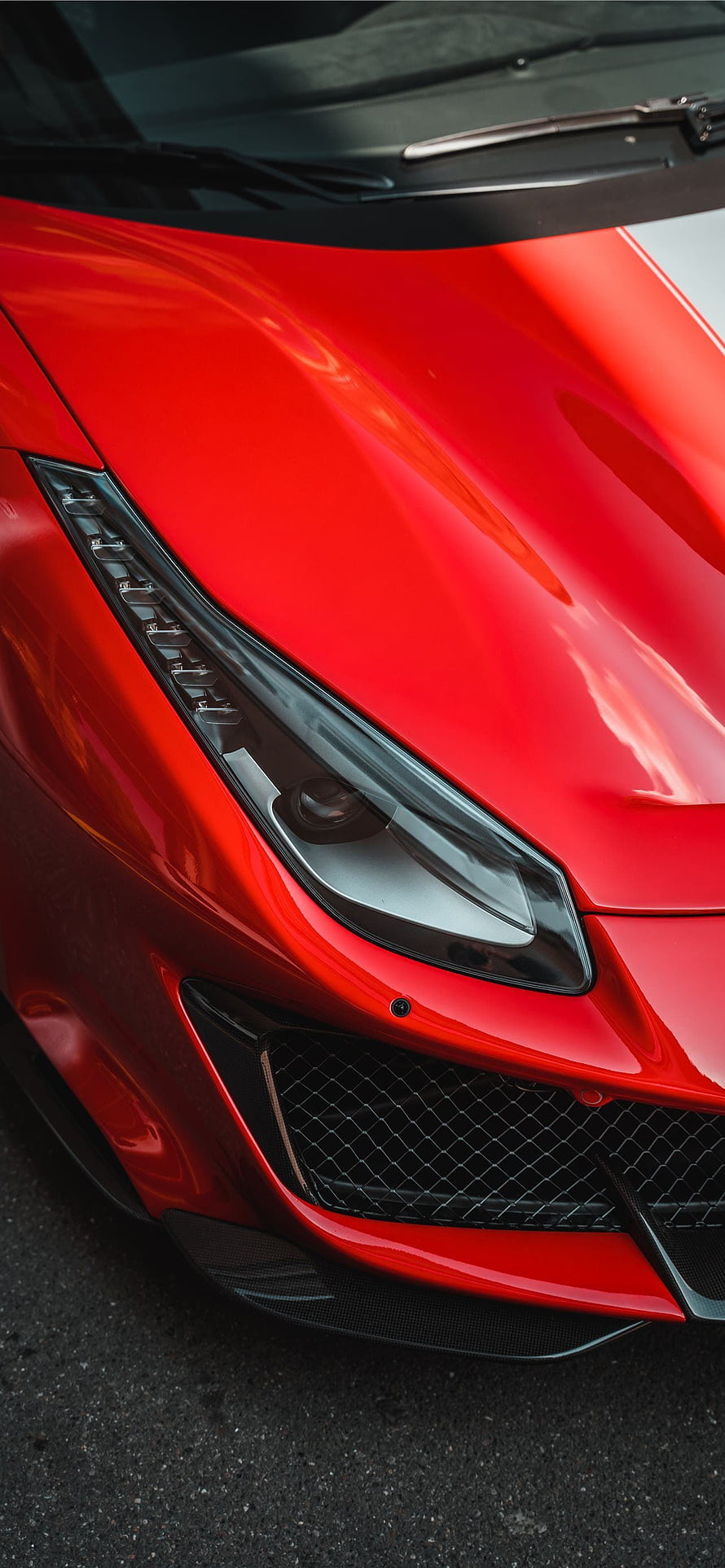 Close-up of a red Ferrari 488 Pista front headlight and carbon fiber grille HD phone wallpaper