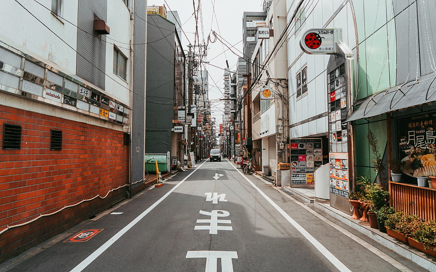 Narrow Japanese City Street with Brick Wall and Overhead Wires HD wallpaper