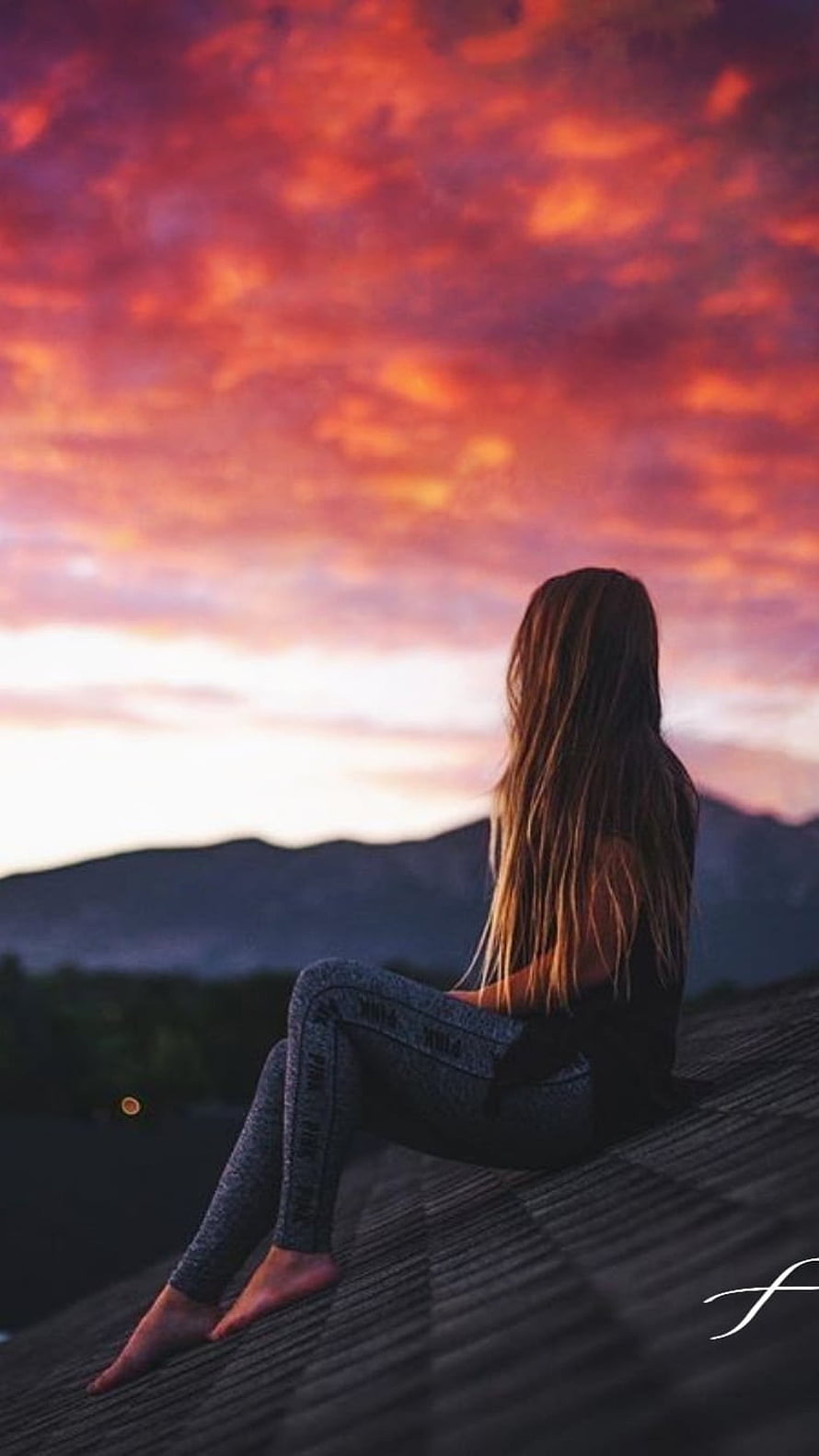 Girl Sitting on Roof Watching Vibrant Sunset Over Mountains HD phone wallpaper