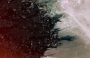 Satellite View of Earth's Coastline with Dark Ocean and Illuminated Landmass HD wallpaper