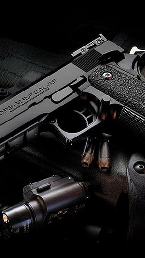 Close-up of a black semi-automatic pistol with tactical flashlight and ammunition on a dark textured surface HD phone wallpaper