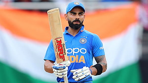 Virat Kohli in India ODI kit holding MRF Genius cricket bat with Indian flag backdrop HD wallpaper