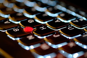 Close-up of a Lenovo ThinkPad keyboard with illuminated keys and red TrackPoint HD wallpaper
