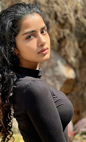 Portrait of a woman with long curly hair wearing a black top outdoors, Anupama parameswaran, actress, anupama_parameswaran, mallu, anupamaparameswaran, Tollywood HD phone wallpaper