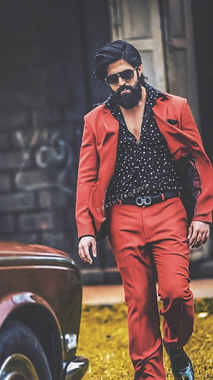 Allu Arjun in a striking red suit and sunglasses from Pushpa 2, exuding confidence and style HD phone wallpaper