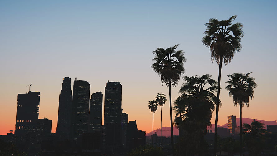 Los Angeles Skyline Silhouette at Sunset with Palm Trees and Distant Mountains HD wallpaper