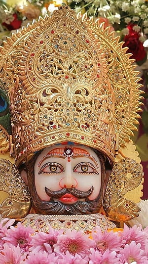 Close-up of Lord Jagannath with ornate golden crown and floral decorations HD phone wallpaper
