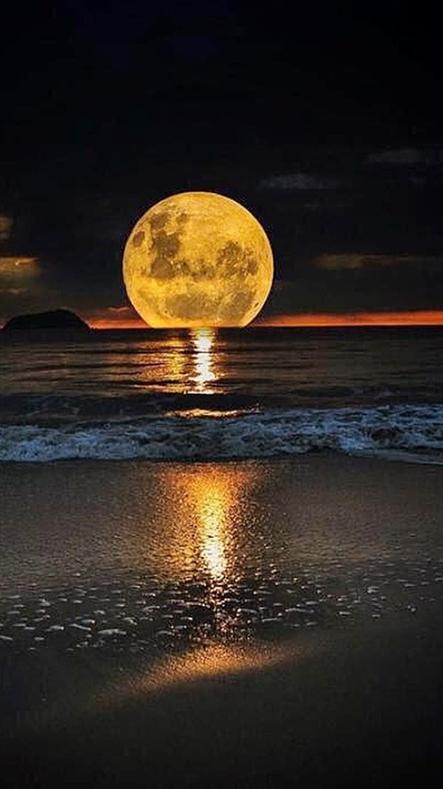 Giant golden full moon rising over a calm ocean with a glowing reflection on the wet sand at dusk HD phone wallpaper