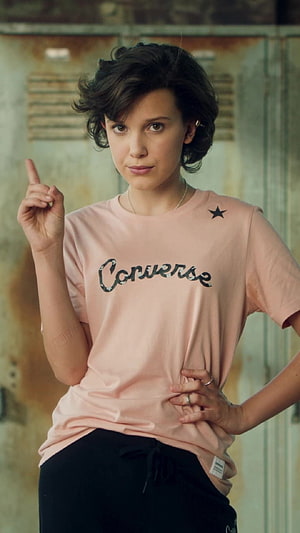Millie Bobby Brown in a Pink Converse T-Shirt with Short Dark Hair HD phone wallpaper