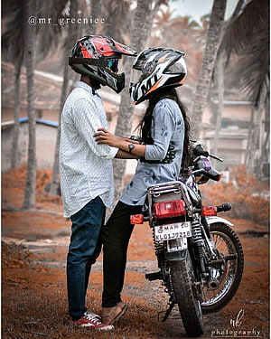 Couple in Motorcycle Helmets Standing Beside a Classic Bike in a Scenic Outdoor Setting HD phone wallpaper