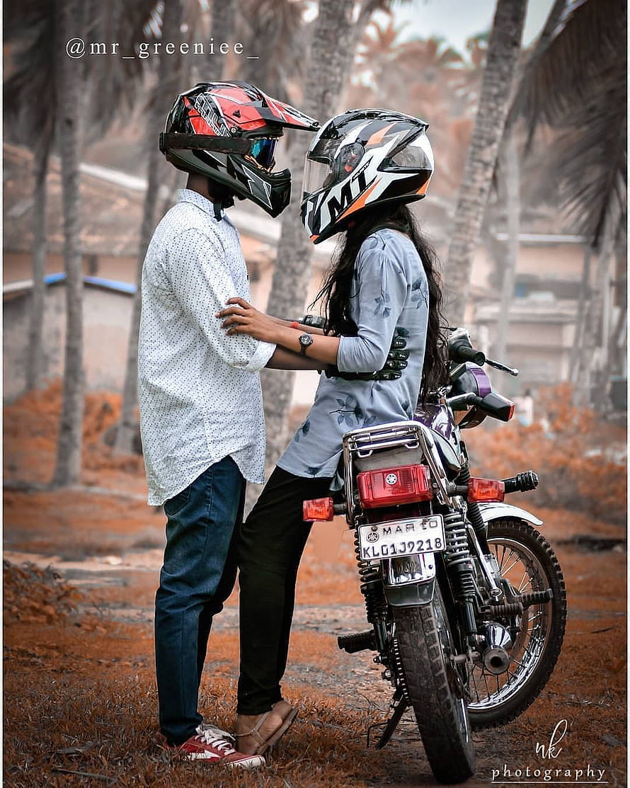 Couple in Motorcycle Helmets Standing Beside a Classic Bike in a Scenic Outdoor Setting HD phone wallpaper